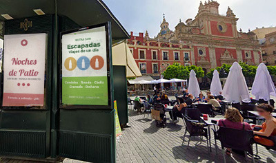 Kiosco en Sevilla con un cartel publicitario de una mujer oliendo una rosa
