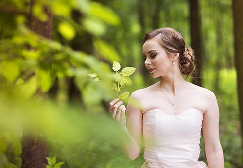 Mujer de pie junto a un árbol en un campo de golf